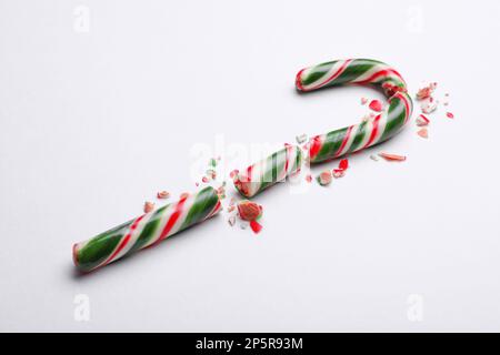 Broken sweet Christmas candy cane on white background Stock Photo