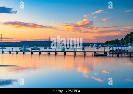 Sunrise in pink and blue with boats and clouds over Brisbane Water from Couche Park at Koolewong on the Central Coast, NSW, Australia. Stock Photo