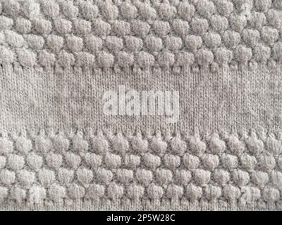 Gray knitted texture of woolen fabric close-up. Textile knit pattern wallpaper abstract background surface for design. Handmade shops matte soft cozy Stock Photo
