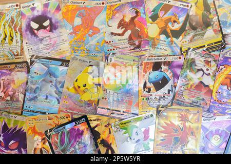 Arahal. Seville. Spain. 1st March 2023. Background created with collectible Pokemon cards on a wooden board. Collectible trading cards based on the Po Stock Photo