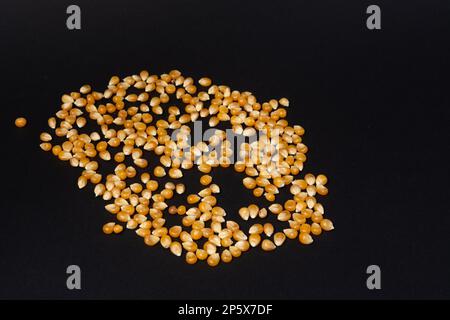 Corn kernels for making popcorn on black background, copy space and top view. Stock Photo