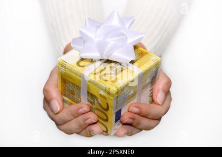 hand with christmas gift, wrapped in 200-Euro-bills Stock Photo