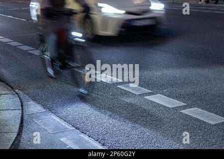 Car overtakes cyclist on bike lanes Stock Photo