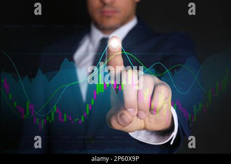 Stock exchange. Businessman pointing at virtual screen electronic online trading platform, closeup Stock Photo
