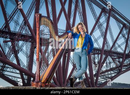 Composer, harpist and singer Esther Swift alongside her Italian Salvi pedal harp during a photocall ahead of her upcoming tour, at the Forth Bridge in North Queensferry. Ms Swift will tour across Scotland solo this month with a programme of original compositions and traditional works. Picture date: Tuesday March 7, 2023. Stock Photo