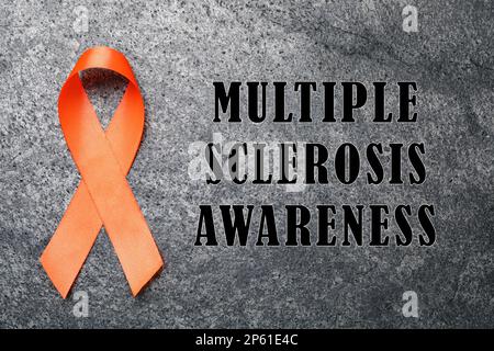 Top view of orange ribbon on dark wood background. Leukemia