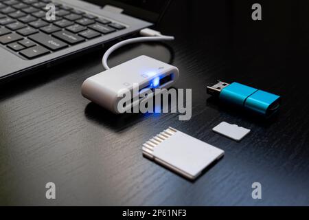 Multiport station for laptop with multiple different ports. Hub Converter. Laptop with USB Type-C adapter with pluged USB cables and SD card. The USB Stock Photo