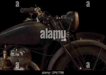 Vintage weathered English motorcycle in front of a black background Stock Photo