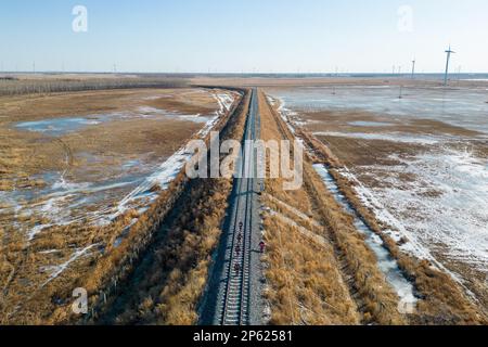 (230307) -- HARBIN, March 7, 2023 (Xinhua) -- This aerial photo taken on March 6, 2023 shows female railway inspectors working in Daqing, northeast China's Heilongjiang Province. At the Dorbod railway line maintenance section of China Railway Harbin Bureau Group Co., Ltd., there is a six-member team of female inspectors with an average age of 29. Their responsibilities include maintaining the railway lines for grain and oil transport, as well as 148 kilometers of Binzhou railway line, which is a crucial part of China-Europe rail transport service line. Despite facing challenging conditions, th Stock Photo