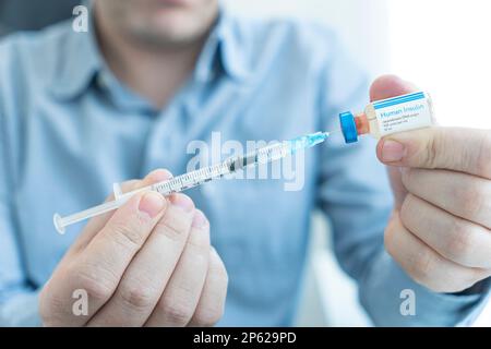 young man hand using insulin syringe close up . injecting insulin at home. self-medication Stock Photo