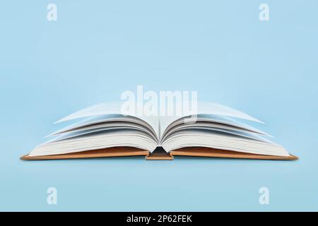 Open book with hard cover on blue background Stock Photo