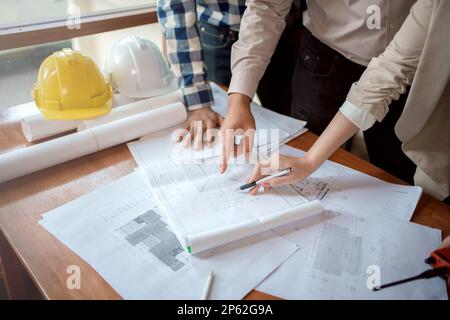 Team of architect and engineer working and discussing about new startup project on desk. Architect discuss with engineer about project  in office. Stock Photo