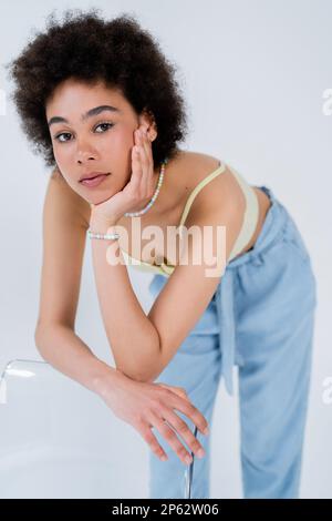 Portrait of young african american woman posing near chair isolated on grey,stock image Stock Photo