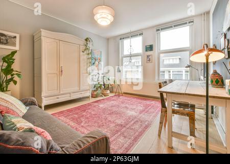 Amsterdam, Netherlands - 10 April, 2021: a living room with a pink rug on the floor and an area rug that has been used for several years Stock Photo