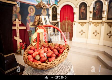 Picture of a basket of easter eggs painted in red in a basket on the altar of the Serbian orthodox church of Bela Crkva in Serbia. it's an easter trad Stock Photo
