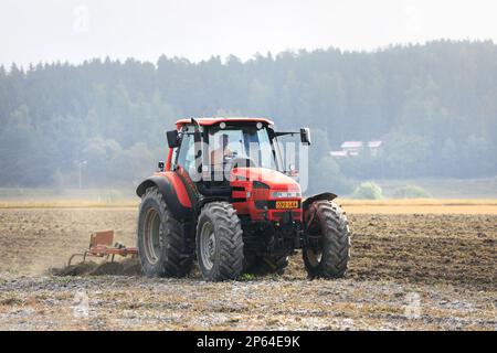 Plowing the field with Same farm tractor and plough on a misty day of early autumn. Salo, Finland. August 27, 2022. Stock Photo