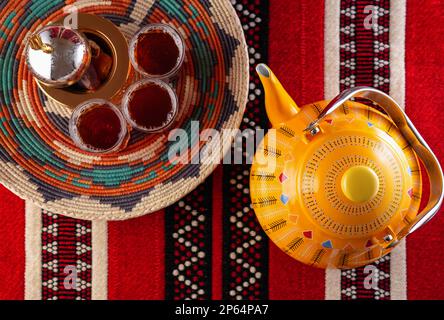 Iconic Arabian fabric is graced with symbols of Arabia, in particular Arabic tea and dates, they symbolise Arabian hospitality, ramadan set Traditiona Stock Photo