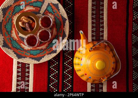 Iconic Arabian fabric is graced with symbols of Arabia, in particular Arabic tea and dates, they symbolise Arabian hospitality, ramadan set Traditiona Stock Photo