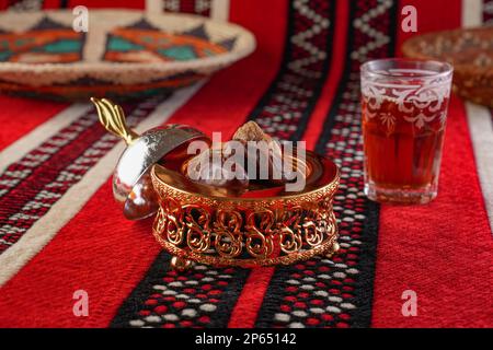 Iconic Arabian fabric is graced with symbols of Arabia, in particular Arabic tea and dates, they symbolise Arabian hospitality, ramadan set Traditiona Stock Photo