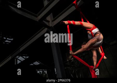 Shara Guzman, a Venezuelan aerial dancer, performs on aerial silks during an art performance in an industrial space in Barranquilla, Colombia. Stock Photo