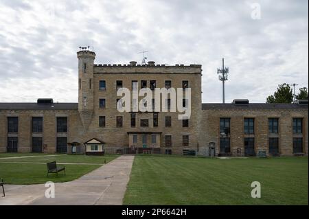 The facade of the historic Joliet Prison against a cloudy sky Stock Photo