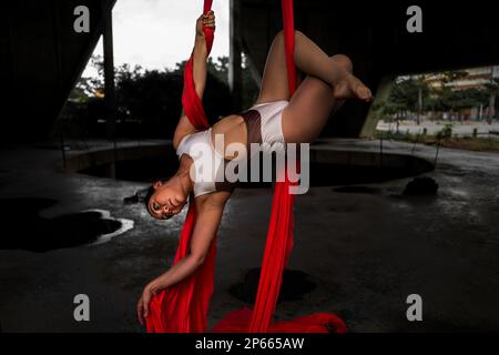 Shara Guzman, a Venezuelan aerial dancer, performs on aerial silks during an art performance in an industrial space in Barranquilla, Colombia. Stock Photo