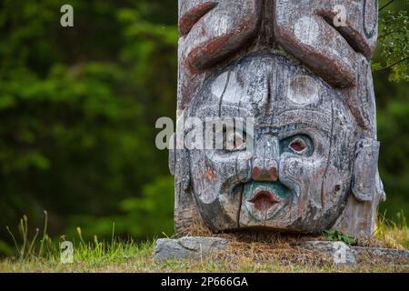 Kwakwaka'wakw totem poles in the cemetery in Alert Bay, Cormorant Island, British Columba, Canada, North America Stock Photo