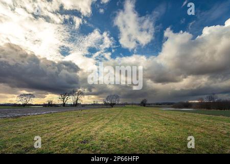 Gray clouds looming over a green meadow, Nowiny, Poland Stock Photo