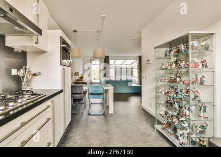 a kitchen with many ornaments on the wall and shelves in the center of the room that is filled with toys Stock Photo
