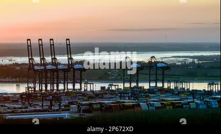 The Felixstowe port cranes on a foggy afternoon, eerily silhouetted against a distant horizon Stock Photo