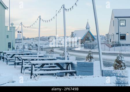 Cullercoats Watch House covered in snow photographed through the fairy lights of the Queens Head pub on Front Street Stock Photo