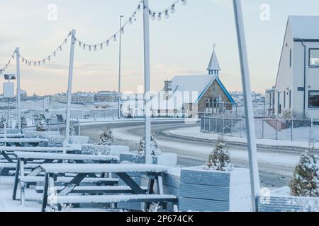 Cullercoats Watch House covered in snow photographed through the fairy lights of the Queens Head pub on Front Street Stock Photo