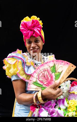 Colourful flower girl with headdress, fan and basket, Havana, Cuba ...