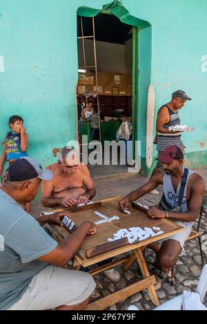 Dominoes game in progress while man leaves the corner shop with eggs, Trinidad, Cuba, West Indies, Caribbean, Central America Stock Photo