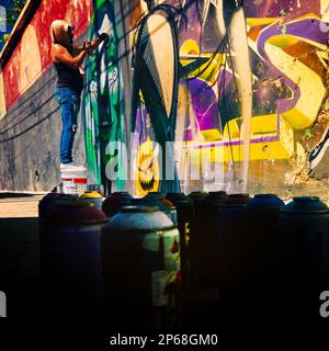 A Mexican street artist paints graffiti on the wall of a cemetery during a graffiti event in Guadalajara, Mexico. Stock Photo