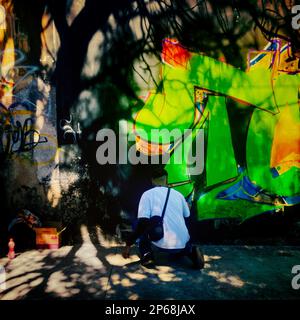 A Mexican street artist paints graffiti on the wall of a cemetery during a graffiti event in Guadalajara, Mexico. Stock Photo