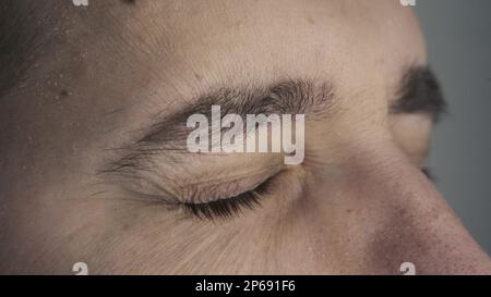 Close-up of blinking green eyes. A young man opens and closes his beautiful eye. Stock Photo