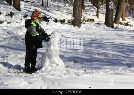 child building snowman Stock Photo