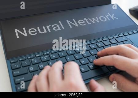 hands typing on laptop on background. Neural network and machine learning concept. the word neural network on the laptop screen. artificial intelligen Stock Photo
