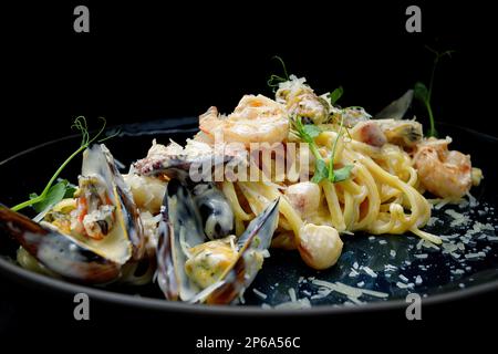 Spaghetti with seafood, mussels, shrimp, octopus, with sauce in a plate Stock Photo