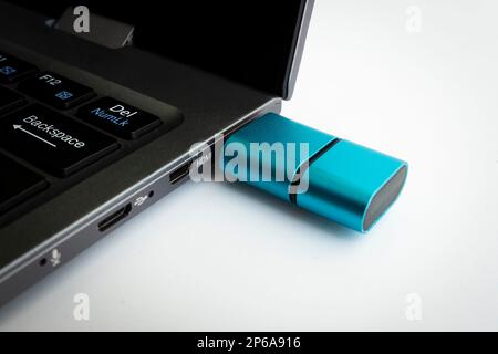 Card Reader Type C on white background. the flash drive is plugged into the laptop connector in close-up. Stock Photo