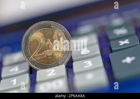 Euro coin on a pocket calculator Stock Photo
