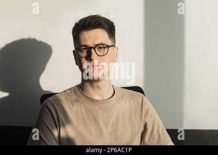 Headshot portrait smart businessman in glasses sitting at work desk in modern office, looking at camera, confident satisfied student freelancer posing Stock Photo