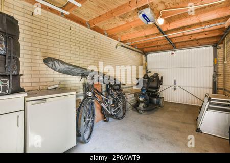 Amsterdam, Netherlands - 10 April, 2021: a garage with a bike parked on the wall and an oven in the kitchen area next to the refrigerator door Stock Photo