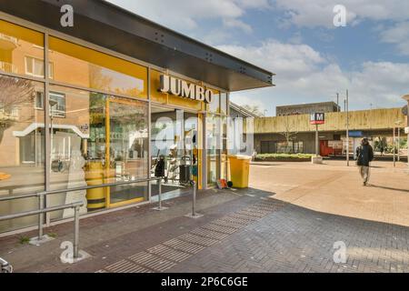 the outside of a building with people walking in it and on the sidewalk, there is a yellow sign that says don't Stock Photo