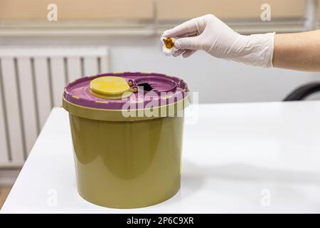 Throw away the medicine in the trash. Disposal container for Infectious waste, reducing medical waste disposal. Small Medical Waste sharps container w Stock Photo