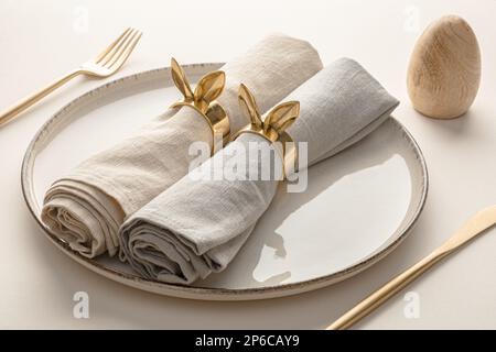 Easter table setting with linen napkins and golden cutlery Stock Photo
