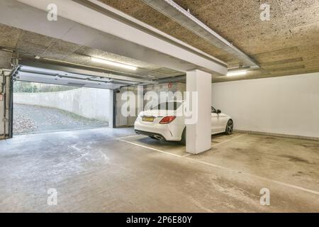 a white car parked in a garage with an open door on one side and the other half of the vehicle Stock Photo