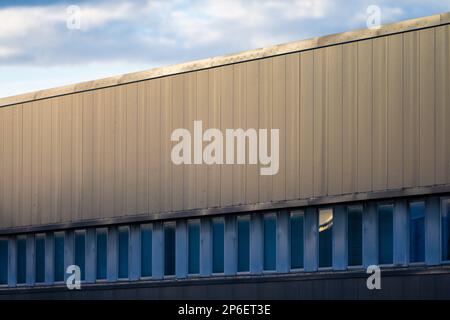 Wall plates above windows of a large warehouse Stock Photo