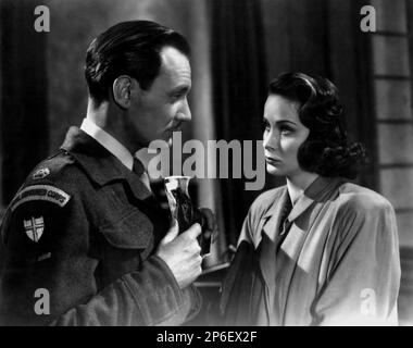 1949 : The  movie actor TREVOR HOWARD with italian actress ALIDA VALLI   in a pubblicitary shot  for THE THIRD MAN ( Il terzo uomo ) by Carol Reed , from a novel by Graham Greene - FILM NOIR  - CINEMA - ATTORE CINEMATOGRAFICO  - FILM - TRILLER - SUSPANCE  - duo - coppia - military uniform - uniforme divisa militare  ----  Archivio GBB      Archivio Stock Photo